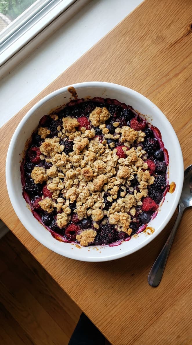 Baked berries crumble with a golden topping in a baking dish